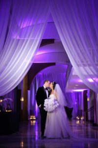 Bride and Groom kissing in the gallery standing