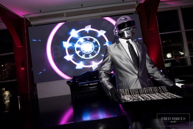 DJ wearing a robot like mask. Lights in the background