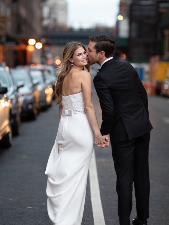 Groom kissing bride in street