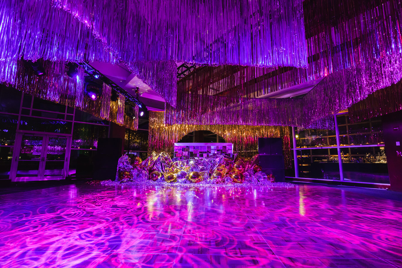 Tinsel hangs above purple-lit dance floor