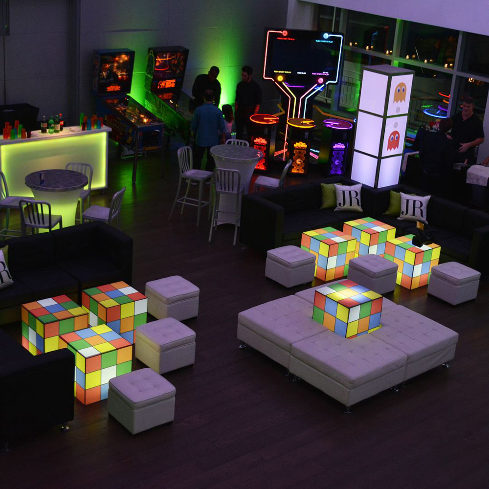 Seating area with giant Rubik cube and arcade games.