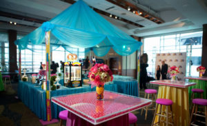 Gumball filled columns hold up blue tent with pretzel machine underneath.