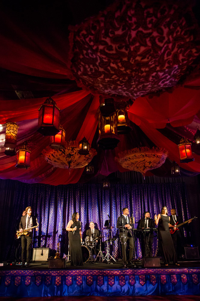 7 person band plays underneath colorful, exotic fabric decorations.