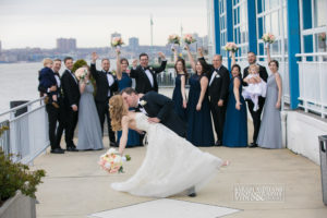 Bride and Groom Kissing in the veranda with bridal party behind