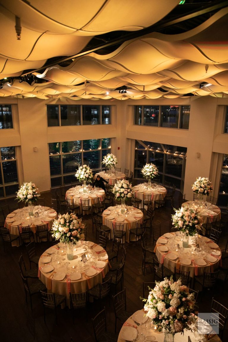 Current Pictures taken from above of the wedding ballroom set for dinner with amber lighting