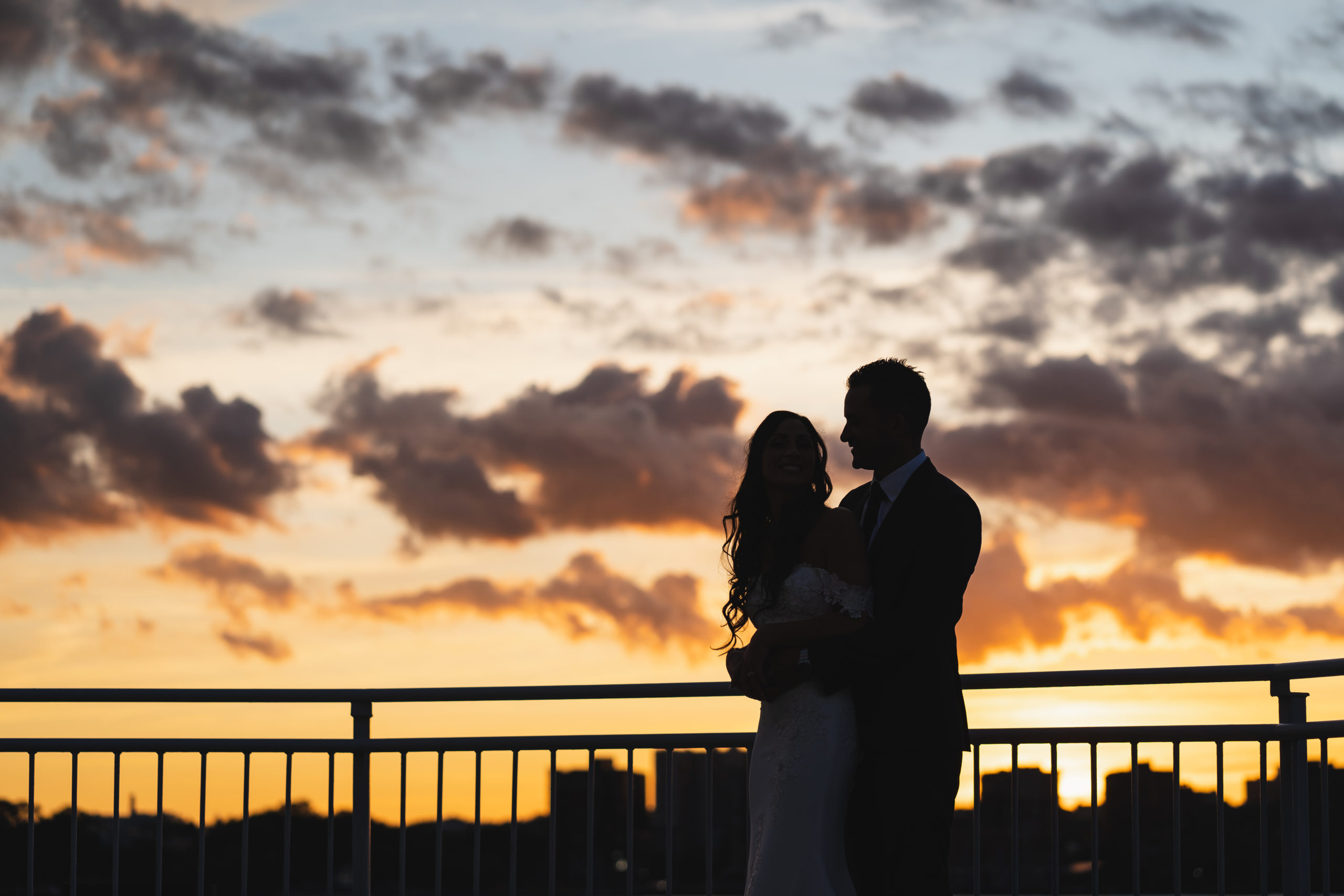 Bride and Groom at the lighthouse veranda over sunset