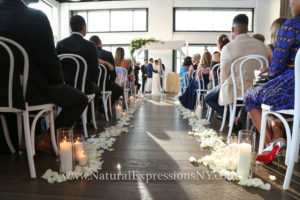 View down the wedding aisle with flowers and candles.