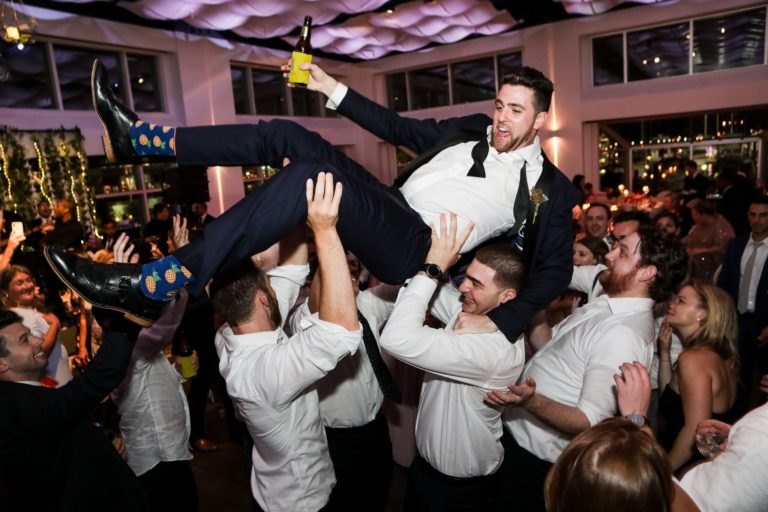Groom being lifted by groomsmen