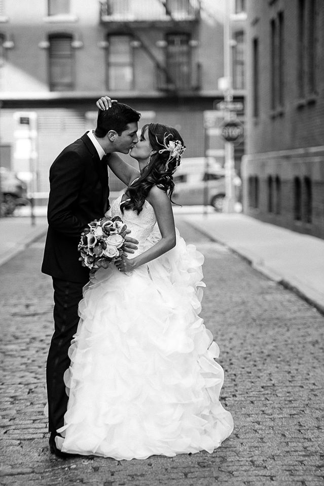 Bride and Groom in the neighborhood of Chelsea kissing while being in the middle of a cobble stone street.