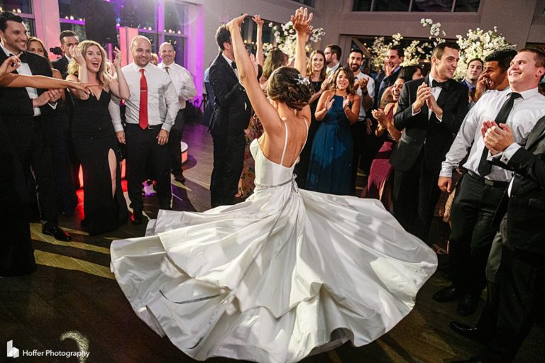 Bride showing her dress spread while dancing with groom at Current