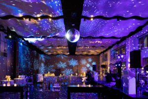 Holiday Party at Current set up in a reception style with hanging disco ball and snowflakes as decor