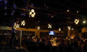 Gala Dinner at The Lighthouse, audience is watching the speaker behind the podium on stage